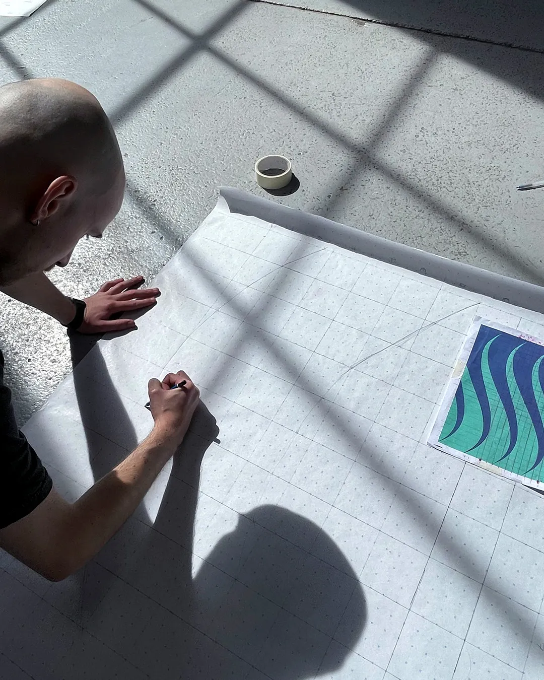 A man drawing on gridded paper.